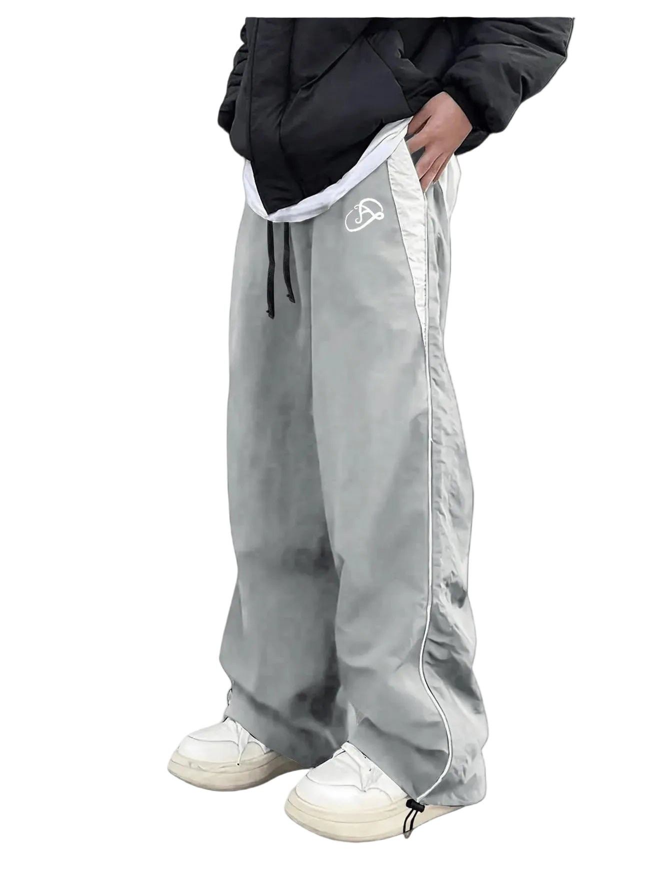 Person wearing gray track pants with a brand logo on a white background