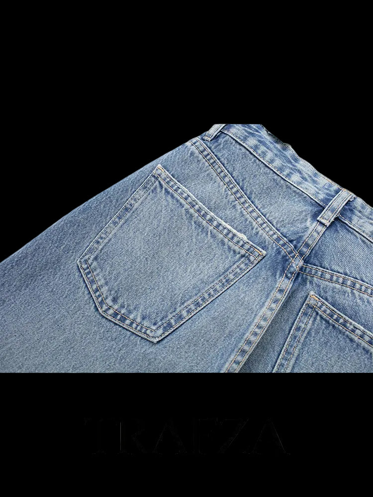Close-up of blue jeans with a Trafza logo at the bottom