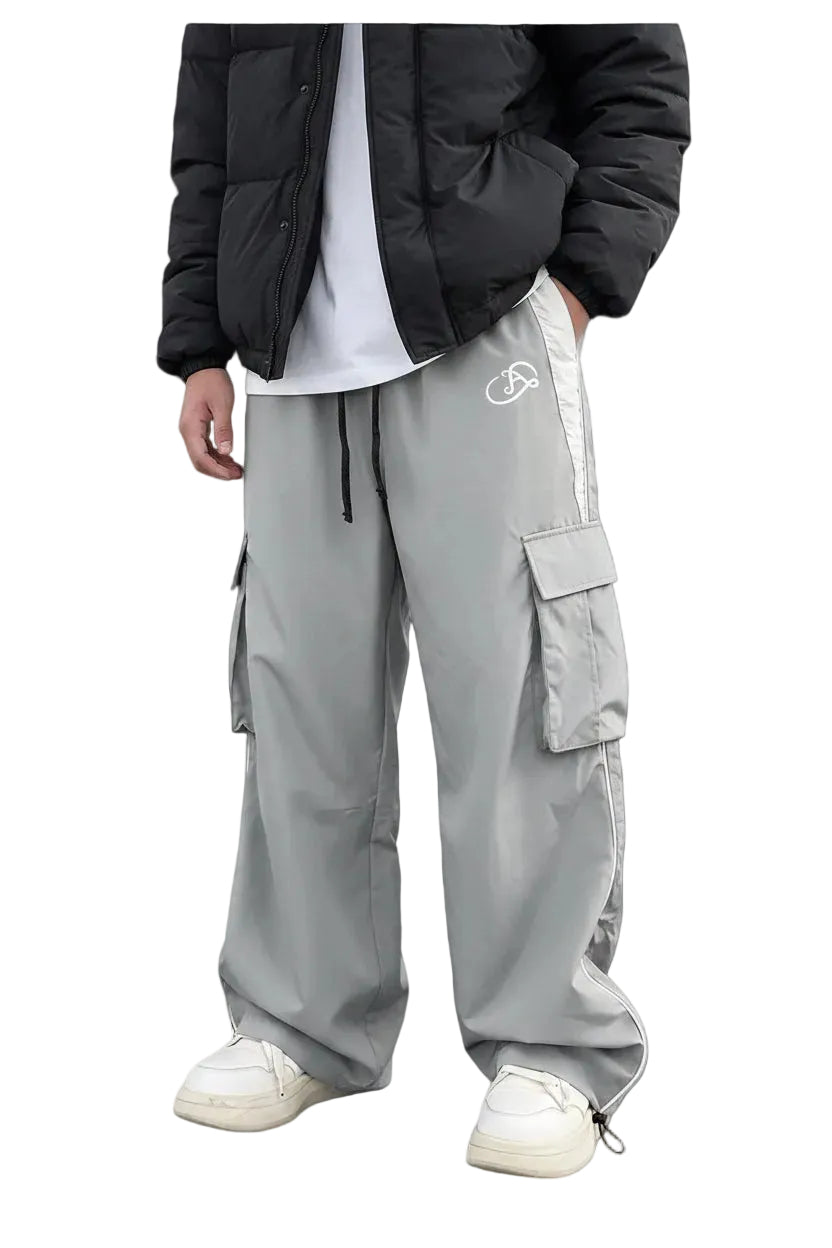 Person wearing gray track pants with a brand logo on a white background