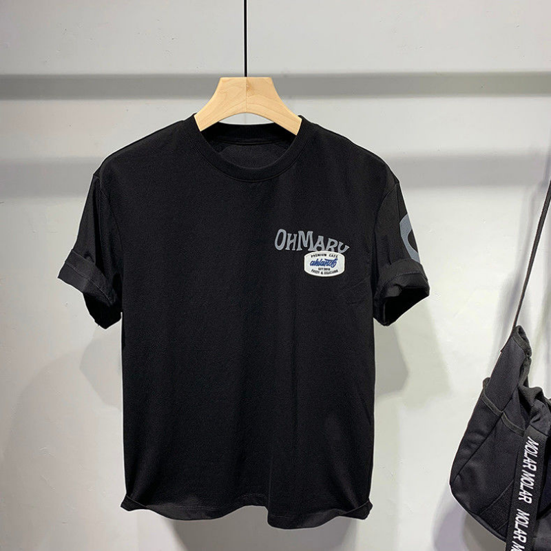 Black t-shirt with branding on a hanger against a neutral background