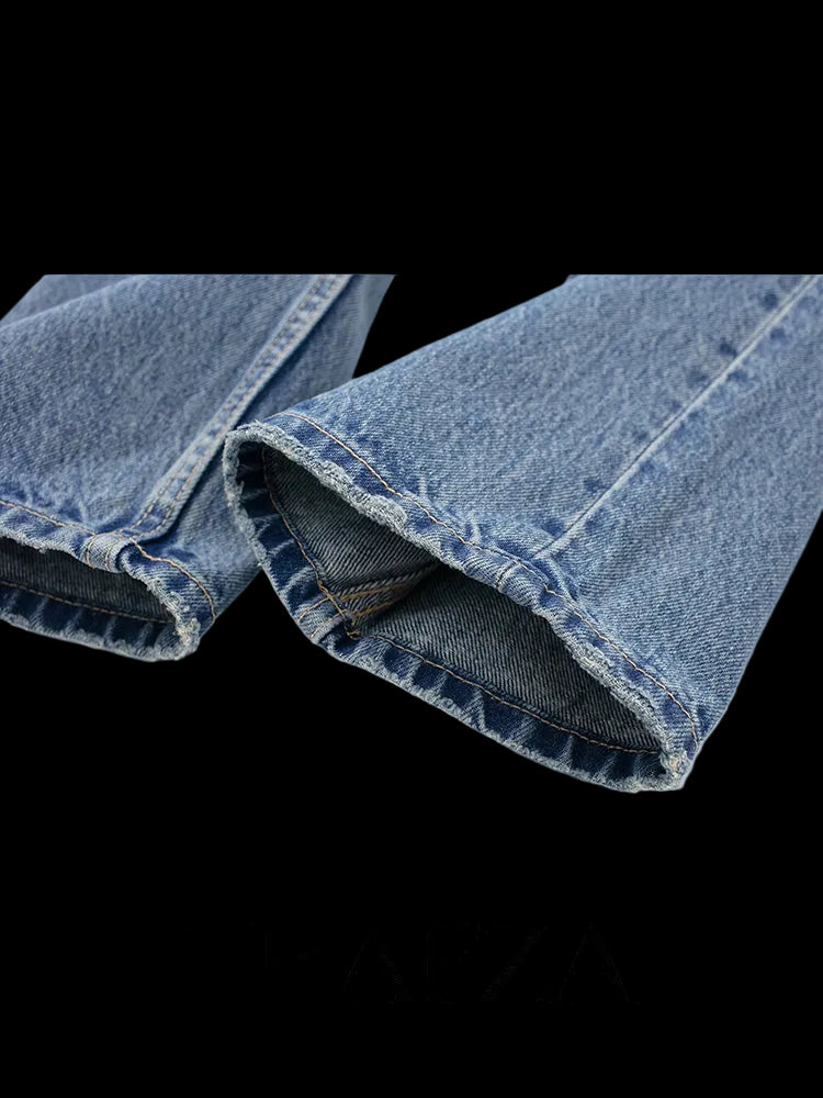 Close-up of folded blue jeans with 'TRAFZA' branding on a white background
